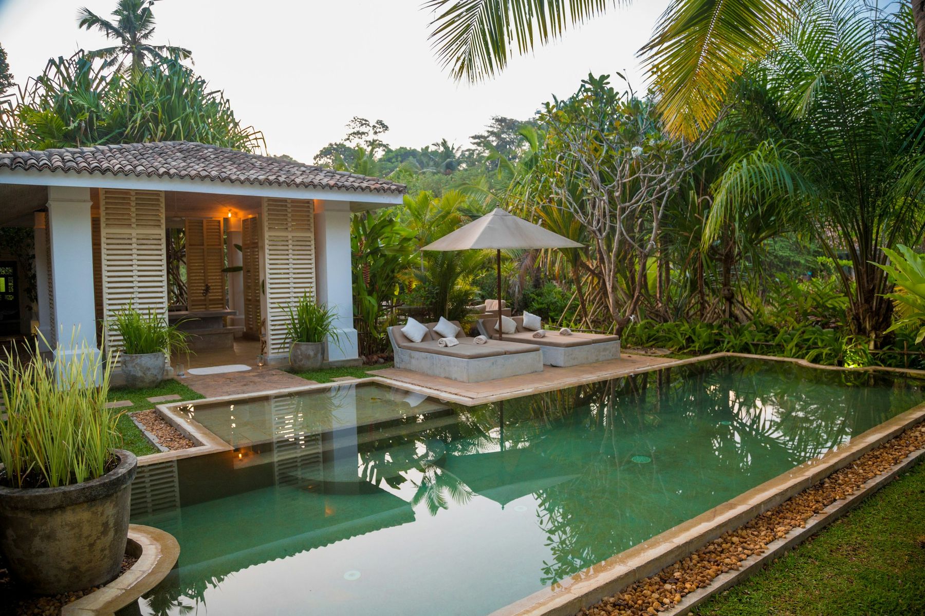 The pool after sunset, paper lanterns lit.
